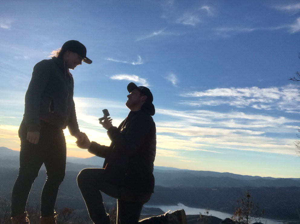 man proposing to girlfriend on top of mountain 